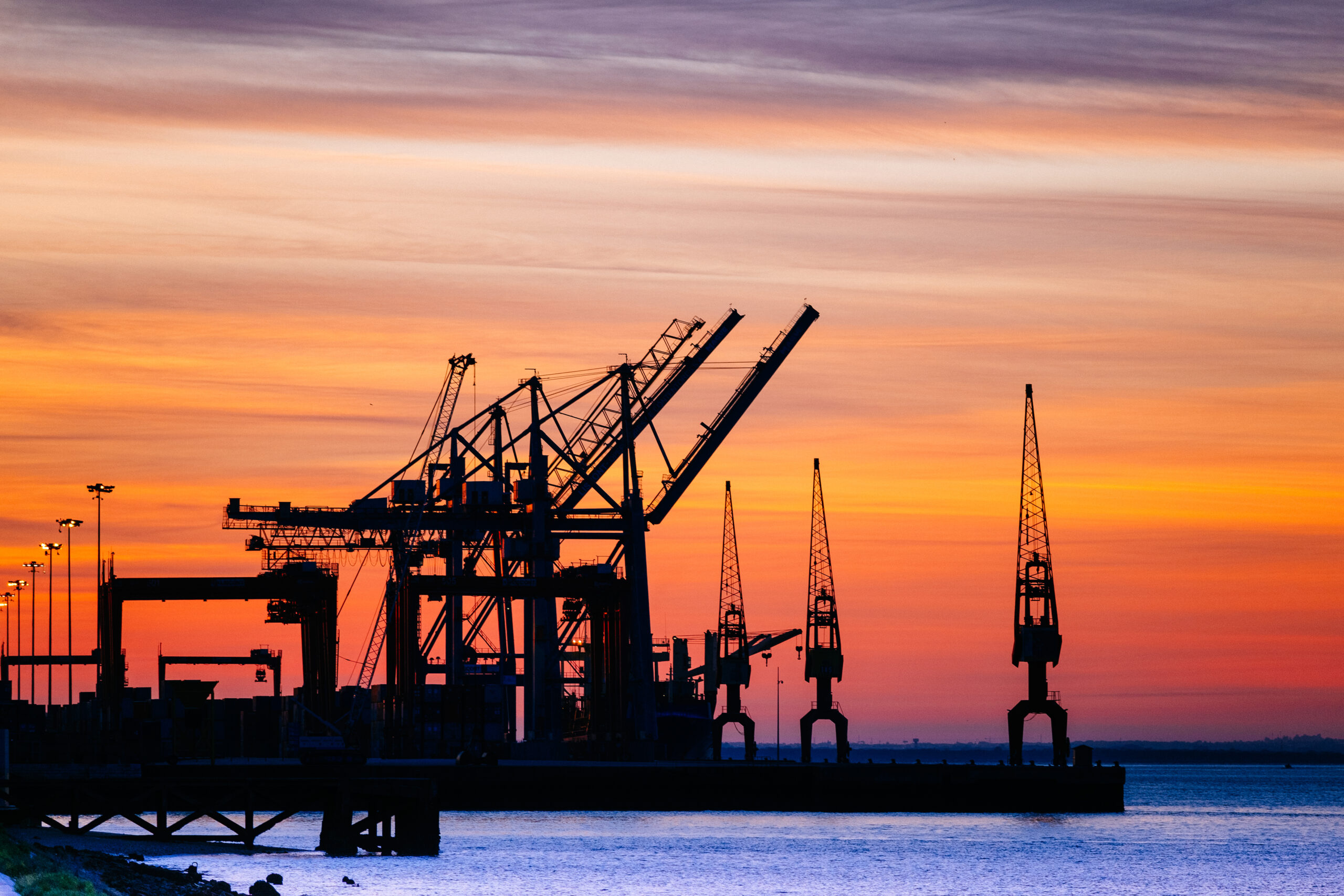 A beautiful silhouette of port machinery during sunset