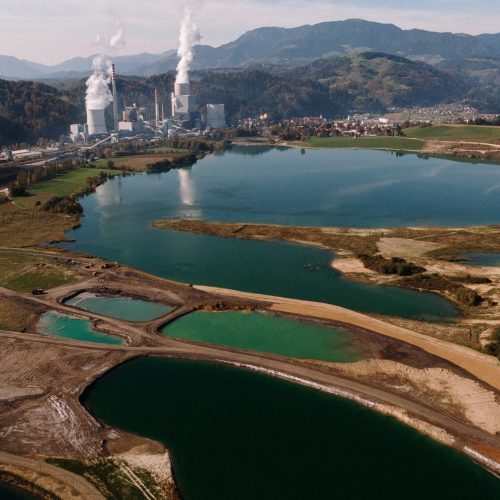 An aerial shot of a landscape surrounded by mountains and lakes with industrial disaster